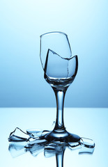 Broken wineglass on blue background