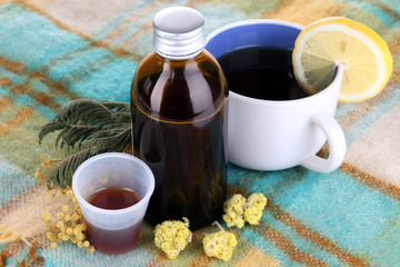 Cough syrup on knitted scarf close-up
