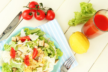 Caesar salad on blue plate, on color wooden background