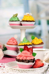 Beautiful strawberry cupcakes on dining table on room