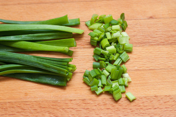 green onion chives on wooden board