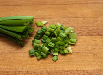 green onion chives  on wooden board