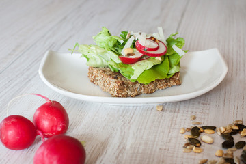 Fototapeta na wymiar Radishes with healthy sandwich with salad