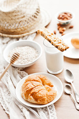 healthy breakfast: croissant, porridge, almonds and milk