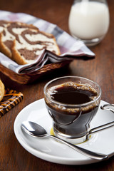 A cup of coffee with a cake basket