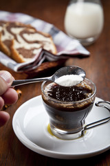 A cup of coffee with croissant and a cake basket