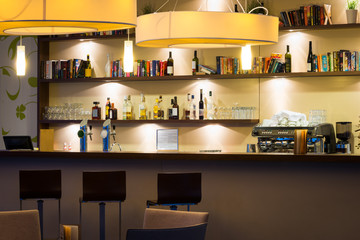 hotel lounge bar with bottle shelfs and seats, tables, ligh