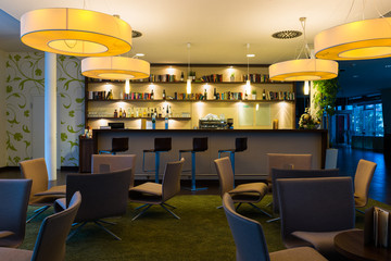 hotel lounge bar with bottle shelfs and seats, tables, lights