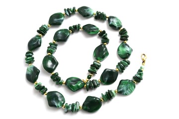 green beads lying on a white background in the form of a spiral