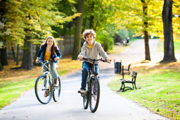 Urban biking - teens riding bikes in city park