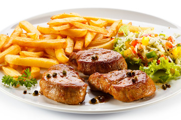 Grilled steaks, French fries and vegetables