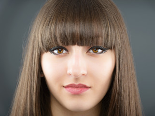 Portrait of a young beautiful woman with bangs in studio