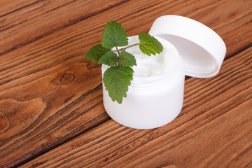 Face cream with mint on a wooden table