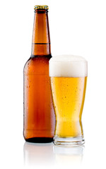 Glass of beer and Brown bottle with drops isolated on a white ba