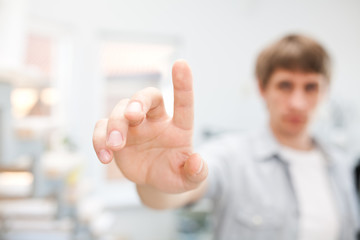 Young man working with virtual screen or pushing button