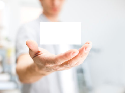 Man holding blank business card with copy space, small dof