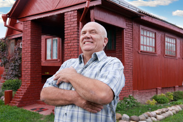 man standing near red house
