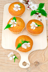 Muffins with jam on a wooden table with flowers
