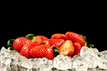 Zelfklevend Fotobehang aardbei op zwarte achtergrond. aardbeien met ijsblokjes erop © EwaStudio
