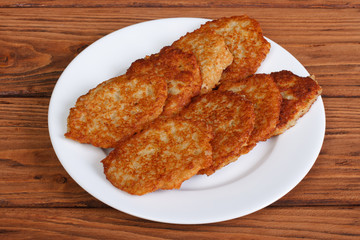 potato pancakes on a white plate on a wooden table