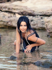 sexual brunette women in water near rocks