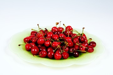 Obraz na płótnie Canvas Fresh red cherries on green plate © Arena Photo UK