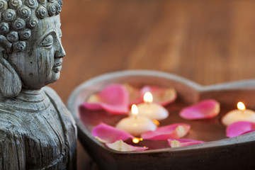 Buddhagesicht und Schwimmkerzen im Herz