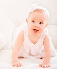 little cute girl in a white dress and with flower smiling