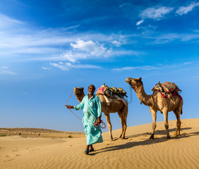 Cameleer (camel driver) with camels in dunes of Thar desert. Raj