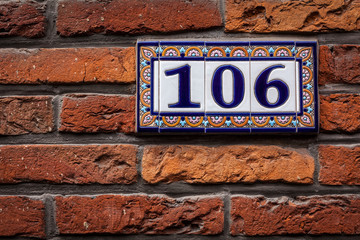 Fototapeta premium Decorated house number on brick wall in Europe. Bruges (Brugge),
