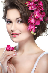 Obraz na płótnie Canvas beautiful brunette with pink orchids in hairs, cosmetics