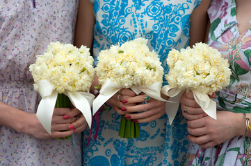 three daffodil wedding bouquets held by bridesmaids