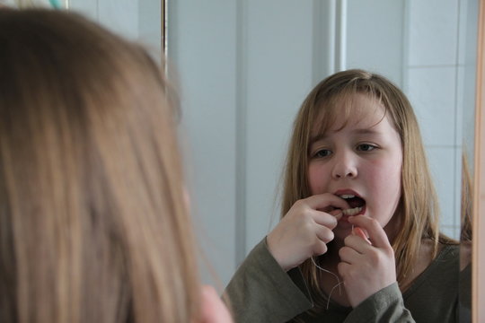M&auml;dchen wendet Zahnseide an