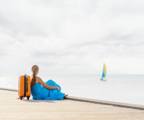 Young woman sitting on wooden pier