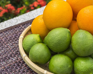 Close up lime and orange fruits in basket