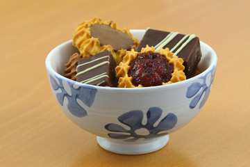 Selection of cookies in bowl on wooden surface