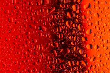 close up water drops on red glass surface