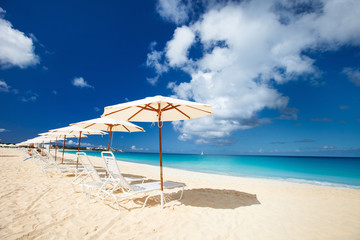 Obraz na płótnie Canvas Leżaki i parasole na tropikalnej plaży
