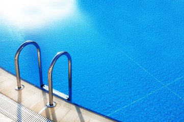 Hotel swimming pool with sunny reflections.