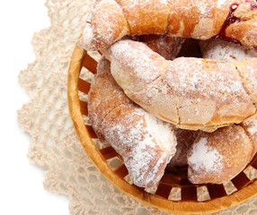 Taste croissants in basket isolated on white.