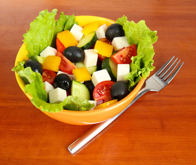 Tasty Greek salad on wooden background