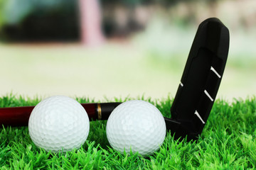 Naklejka premium Golf balls and driver on green grass outdoor close up