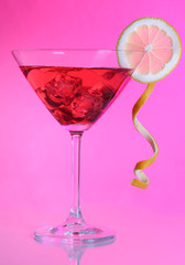 Red cocktail in martini glass  on pink background