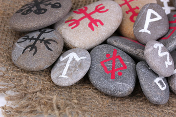 Fortune telling  with symbols on stones on burlap background