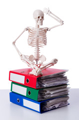 Skeleton with pile of files on white