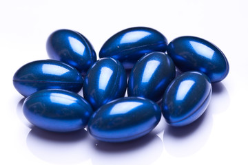 blue vitamin gel capsules isolated on pastel background 
