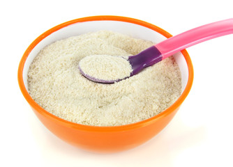 Powdered milk in bowl and spoon for baby isolated on white