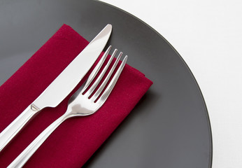 Cutlery on red napkin with black plate - Powered by Adobe