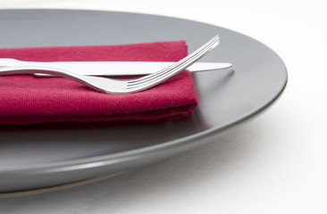 Place setting with black plate and cutlery