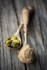 Close up of spoons of ground cardamom and pods